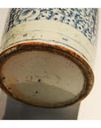 Close-up of blue floral designs on the base of a hand-painted Chinese antique ceramic vase with a worn, unglazed rim.