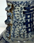 Close-up of blue and white ceramic Chinese antique vase with hand-painted patterns and sculpted neck details.