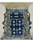 Close-up of blue and white hand-painted ceramic Chinese antique vase with central Chinese character pattern.