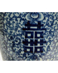 Close-up of blue and white ceramic Chinese vases with hand painted floral patterns and bold character symbols, weathered finish.