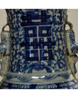 Close-up of blue and white ceramic Chinese vase with hand painted patterns and Chinese characters, weathered finish.