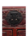 Close-up of dark metal latch on carved dark red lacquer wood Chinese jewelry box.
