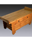 Gray antique Chinese wood cabinet with everted flanges, two drawers, and high flared armrests against gray backdrop.