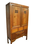 Dark wood Chinese kitchen cabinet with hand-carved frame, three drawers, and decorative legs, front view.