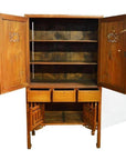 Brown wood kitchen cabinet with open top and bottom doors, shelves, three drawers, and slatted bottom shelf indoors.