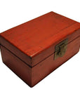 Close-up of a red lacquered rectangular wooden box with a sturdy metal latch on the front, antique Chinese style.