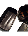 Black and red lacquered rectangular tiered food basket, empty, on a white background.