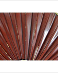 Close-up of red pleated and gold-trimmed antique Chinese flags or fan, set against a white background.