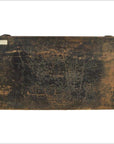 Close-up of an antique Chinese low kang coffee table with worn wood, faded black paint, and a weathered white label.