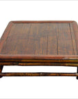 Brown wood square Chinese low kang ceremonial table with flat top, rounded edges, and short legs on plain background.