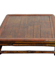 Brown wood square Chinese low kang ceremonial table with flat top, rounded edges, and short legs on plain background.