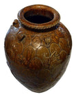 Close-up of large brown ceramic Chinese Martaban water jar with carved patterns and decorative details.
