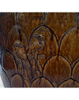 Brown ceramic Chinese Martaban water jar with scalloped pattern and two carved birds, rustic style, close-up.