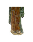 Close-up of brown and green glazed terracotta court figure statue base and feet.