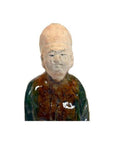 Green-brown terracotta court figure statue with tall hat, close-up on white background.