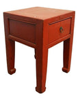 Red lacquered wood side table with a single drawer, metal ring handle, and four straight legs, antique style.