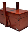 Close-up of antique Chinese red lacquer wood box with handle, showing distressed edges and visible wear.