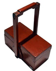 Red lacquer wood box with rectangular shape and tall handle, antique Chinese style, close-up view.