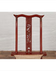 Red lacquered wood folding chair with fabric seat and footrest, indoors against white brick wall on wood floor.