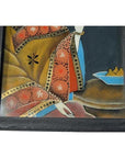 Antique Chinese reverse glass painting, figure in ornate dress by table with blue dish, wood frame, close-up view.