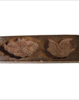 Brown wooden Chinese rice mold with carved lotus and Fu bat motifs, close-up on a white background.