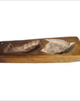 Brown wood antique Chinese rice mold with carved koi fish and lotus blossom designs, close-up on white background.