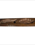 Brown wooden antique Chinese rice mold with carved fish and floral medallions, close-up view on neutral background.