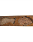 Close-up of antique wooden Chinese rice mold with carved fish and floral medallion motifs, other styles visible nearby.