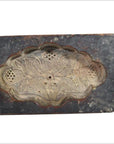 Brown antique Chinese wooden rice mold with intricate floral design and holes, close-up, on neutral background.