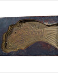 Brown wooden antique Chinese rice mold with carved fish design, showing scale and fin details, close-up view.