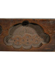 Brown wood antique Chinese rice mold with carved dome, cloud pattern, and circular holes, close-up on plain surface.
