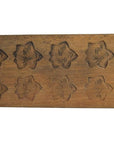 Brown wooden antique Chinese rice mold with 18 plum blossom cavities, long format, close-up on white background.
