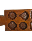 Brown antique Chinese wooden rice mold with carved floral and geometric patterns, close-up.