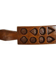Brown wood antique Chinese rice mold with 8 floral and geometric cavities, close-up view on neutral background.