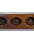 Close-up of antique Chinese rice mold with three scalloped round indentations, ceramic material visible.