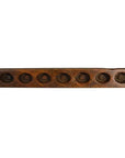 Brown wooden antique Chinese rice mold board with seven round indentations in a row, close-up view.