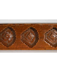 Brown antique Chinese rice mold with three repeating diamond-shaped floral patterns, wood material, close-up view.