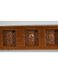 Close-up of antique wooden Chinese rice mold with ornate rectangular sections, shown on a plain surface.