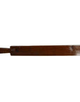 Close-up of antique Chinese rice mold, flat rectangular wooden paddle with small handle on the left side, wood texture.