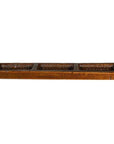 Brown wooden antique Chinese rice mold with four compartments and vertical spikes, close-up on a plain surface.