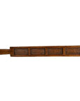 Brown wooden antique Chinese rice mold with four rectangular patterned sections and a handle, close-up view.