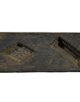 Brown antique Chinese wooden rice mold with coin, fish, and diamond cavities on a weathered surface, close-up.