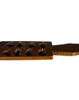 Brown wooden Chinese rice mold with eight geometric cavities and handle, close-up on plain background.