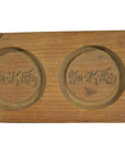 Light wood antique Chinese rice mold with three round character stamps, close-up.