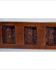 Brown antique Chinese wooden rice mold with seven rectangular motifs, close-up on a flat surface.