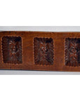 Brown antique Chinese wooden rice mold with seven rectangular motifs, close-up on a flat surface.