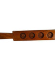 Close-up of solid walnut antique Chinese rice mold paddle featuring four carved floral molds on wood surface.