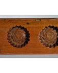 Close-up of antique walnut-finish Chinese rice mold paddle with two round floral cavities, solid wood.