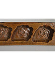 Close-up of brown antique wooden Chinese rice mold with five carved symbol cavities, used for decor or printing.
