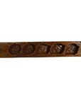 Brown wooden antique Chinese rice mold with five uniquely carved symbol cavities, close-up view.